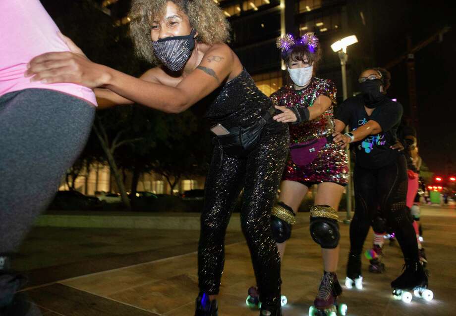 The Space City Roller members skate like a train while having fun with a Friday night skate Friday, Nov. 20, 2020, at Discovery Green in downtown Houston. The Space City Roller is a Houston-based girl group of roller skaters. Photo: Yi-Chin Lee, Houston Chronicle / Staff Photographer / © 2020 Houston Chronicle