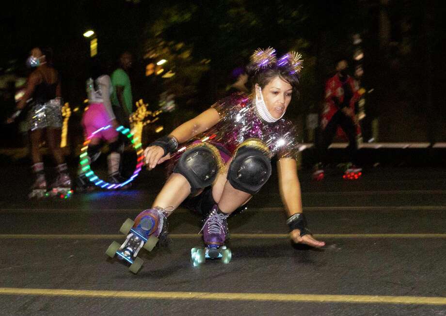 Sherry Carabes skates in freestyle while the Space City Roller members are having fun with a Friday night skate Friday, Nov. 20, 2020, at a parking lot in downtown Houston. The Space City Roller is a Houston-based girl group of roller skaters. Photo: Yi-Chin Lee, Houston Chronicle / Staff Photographer / © 2020 Houston Chronicle