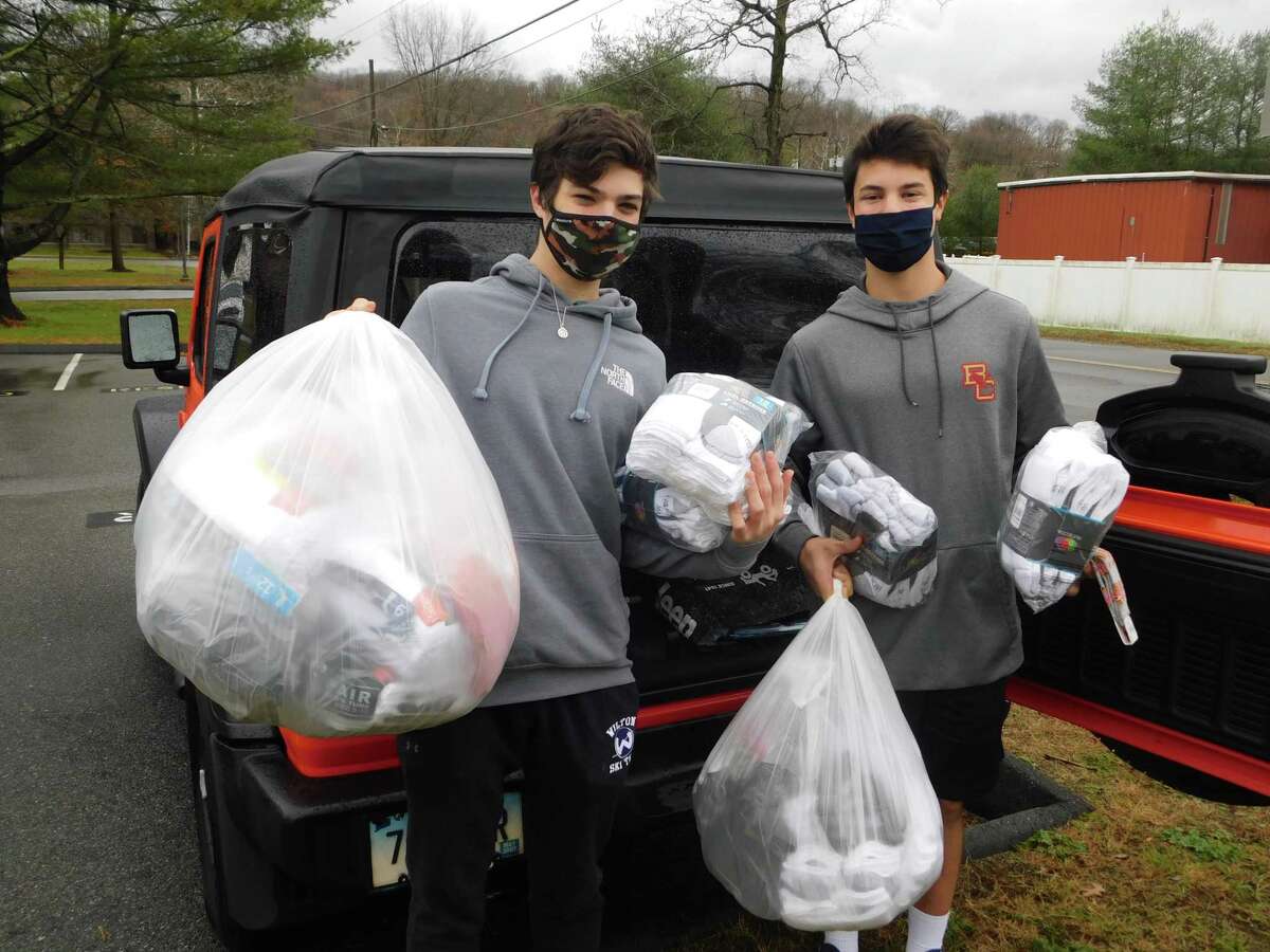 Wilton High School students Elijah Ackerman and Tyler Casey hold bags of socks to be donated to soldiers and veterans. The socks were collected by the Socks for Soldiers club during its Veterans Day drive.