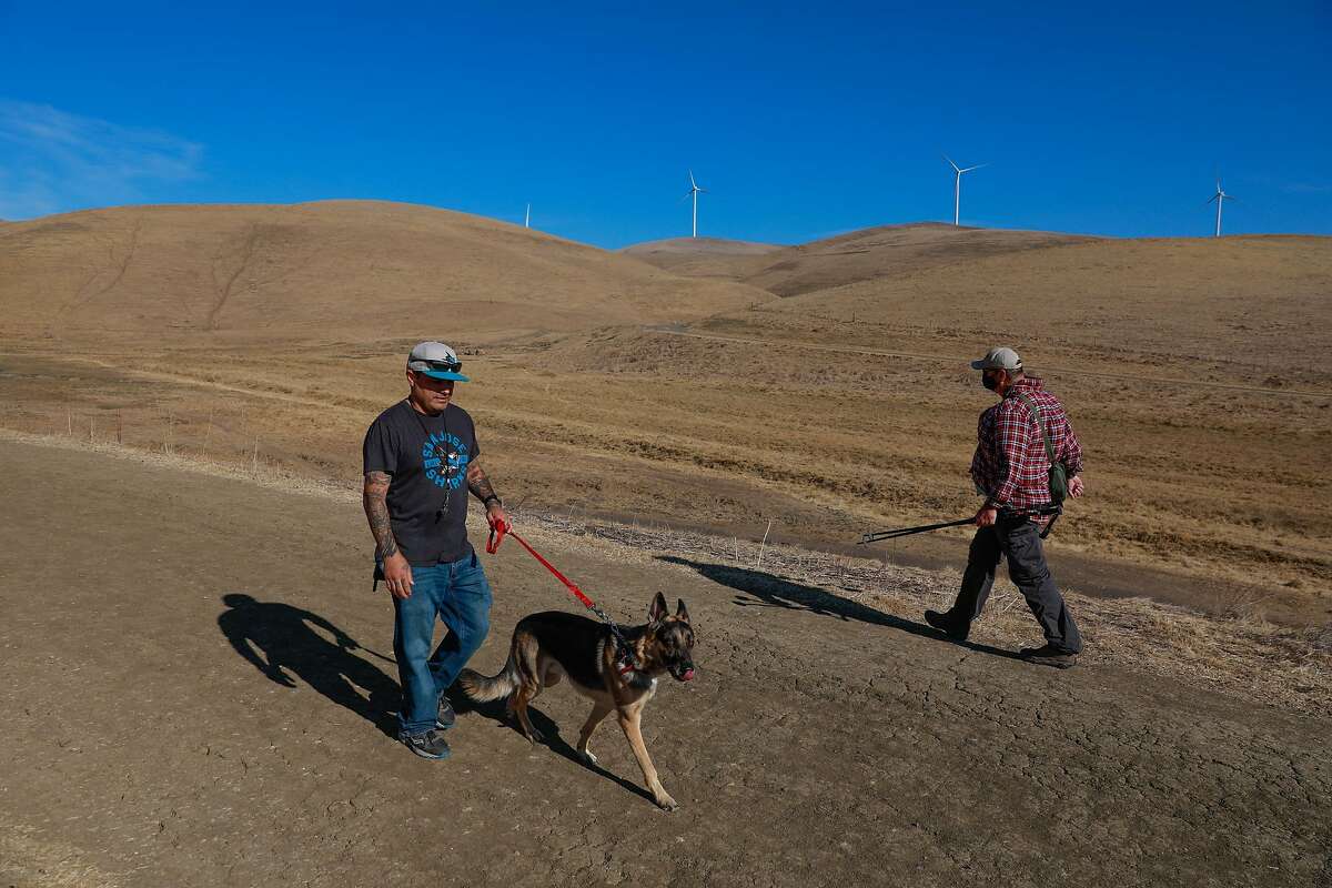 Victor Trujillo (left) and his dog Benedict hike on a trail in Brushy Peak Regional Preserve on Monday, Nov. 16, 2020 in Livermore, California. A calamitous year of deadly fires was thought to be over after a spate of rainstorms last month. But no rain clouds have graced Bay Area skies since, and none are expected in the coming weeks, experts said Dec. 1, sparking renewed fears of fire.