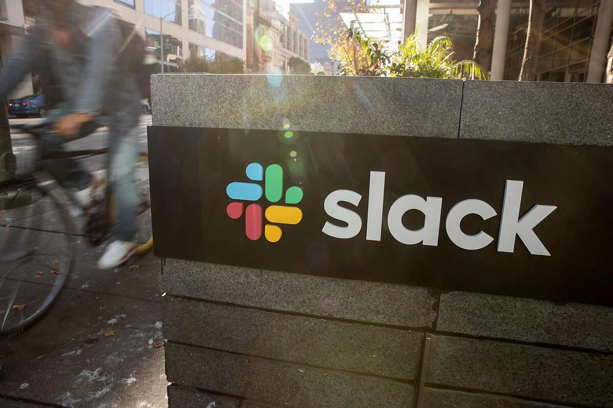 A bicyclist cycles past a Slack logo outside its headquarters on Dec. 1, 2020, in San Francisco.