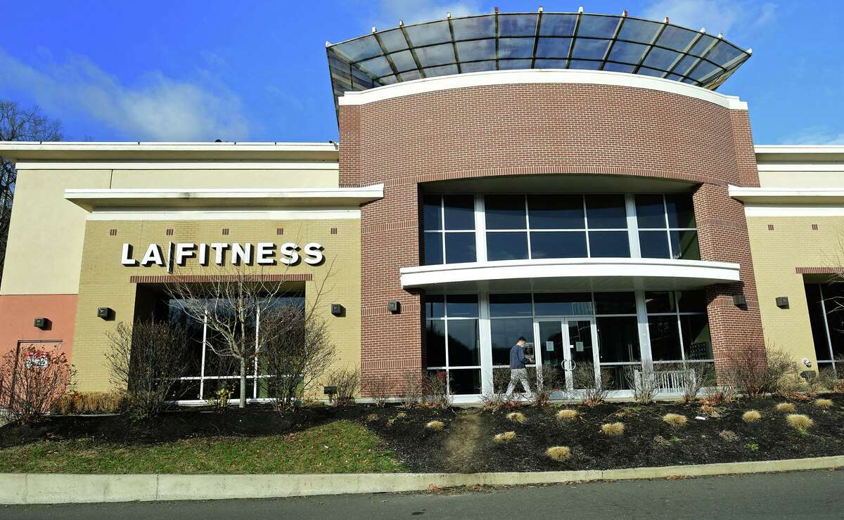 Patrons visit the LA Fitness Norwalk location to find that it has been closed Wednesday, December 2, 2020, at iPark in Norwalk, Conn. The Norwalk Health Department and Norwalk Police Department signed a closure order for LA Fitness today due to several repeated violations of State of Connecticut sector rules. Violations include patrons not wearing facemasks or other cloth face coverings, failure to maintain six feet of space between equipment and people, and failure to enforce the revised capacity limits.