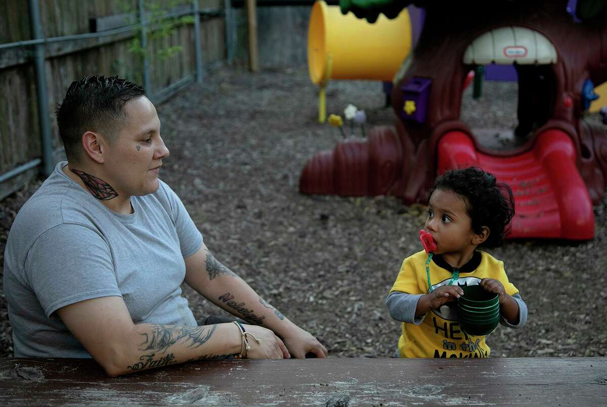 Genevieve Poblano sits with her son, Ayden Poblano, and talks about how close she is to earning her GED in the backyard at Casa Mia, a supportive housing program that allows children to stay with their mothers as they recover from substance abuse.