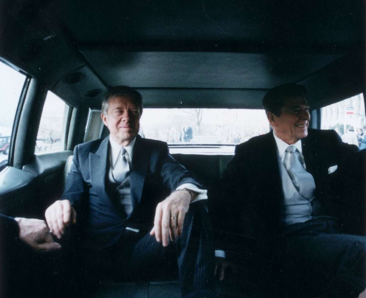 Outgoing President Jimmy Carter sits with President-elect Ronald Reagan in the back of a limousine en route to Reagan's inauguration, Jan. 20, 1981, in Washington, D.C.