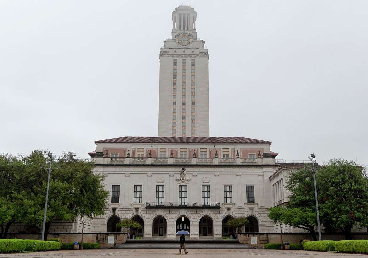 A man walks in front of the UT Tower on the University of Texas campus on Monday, March 30, 2020, in Austin.
