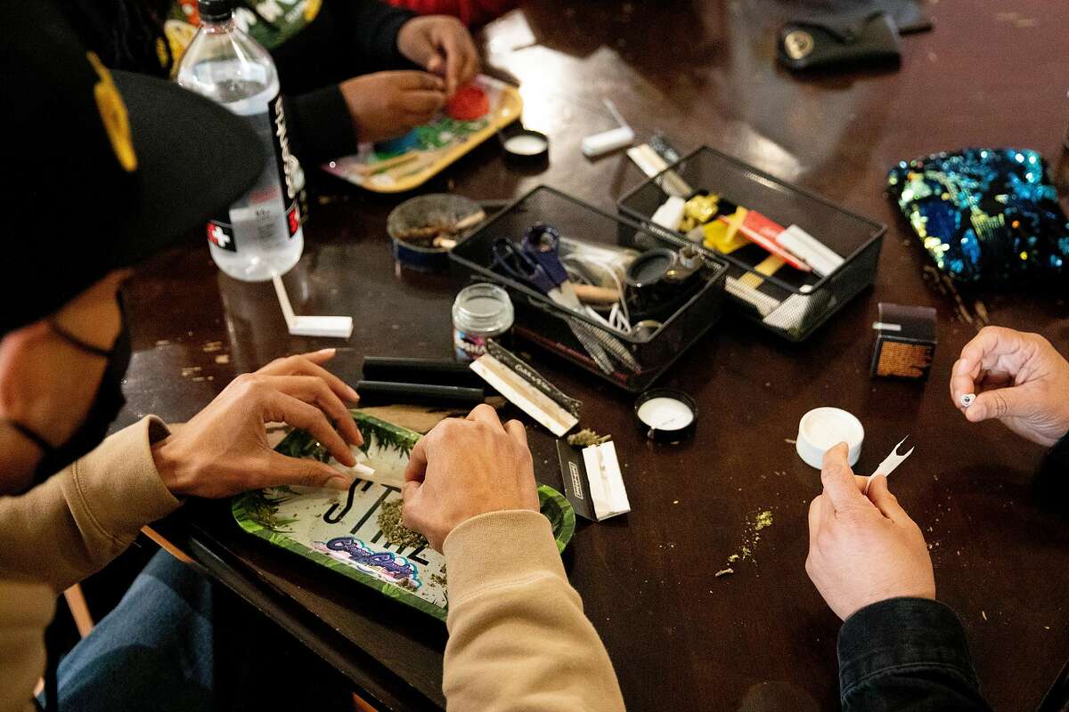 Showboat (left) and Ivan Castro wear masks while rolling joints at the Berner’s on Haight dispensary.
