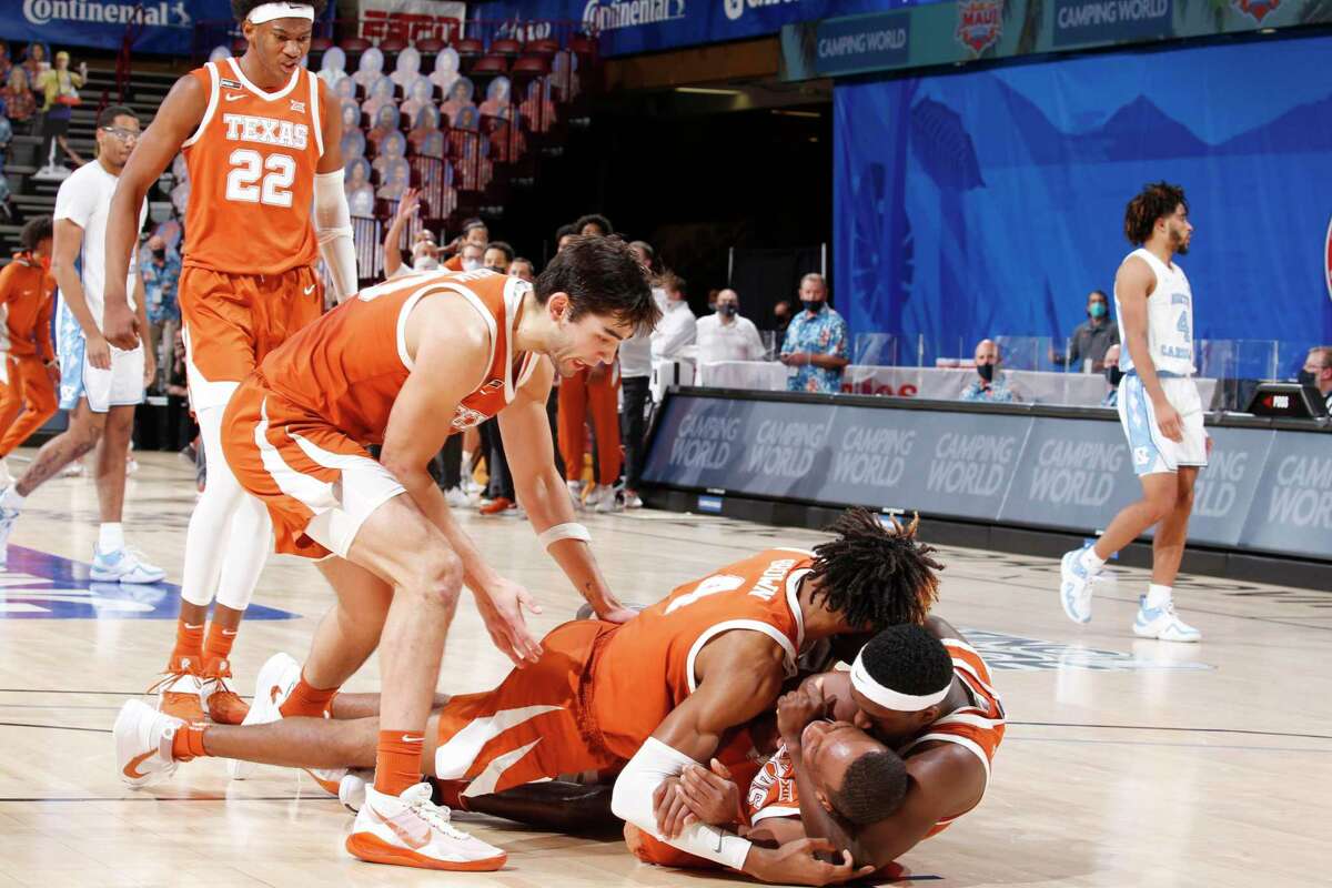 The Longhorns mob guard Matt Coleman after he made the game-winning shot to beat North Carolina in Asheville, N.C.