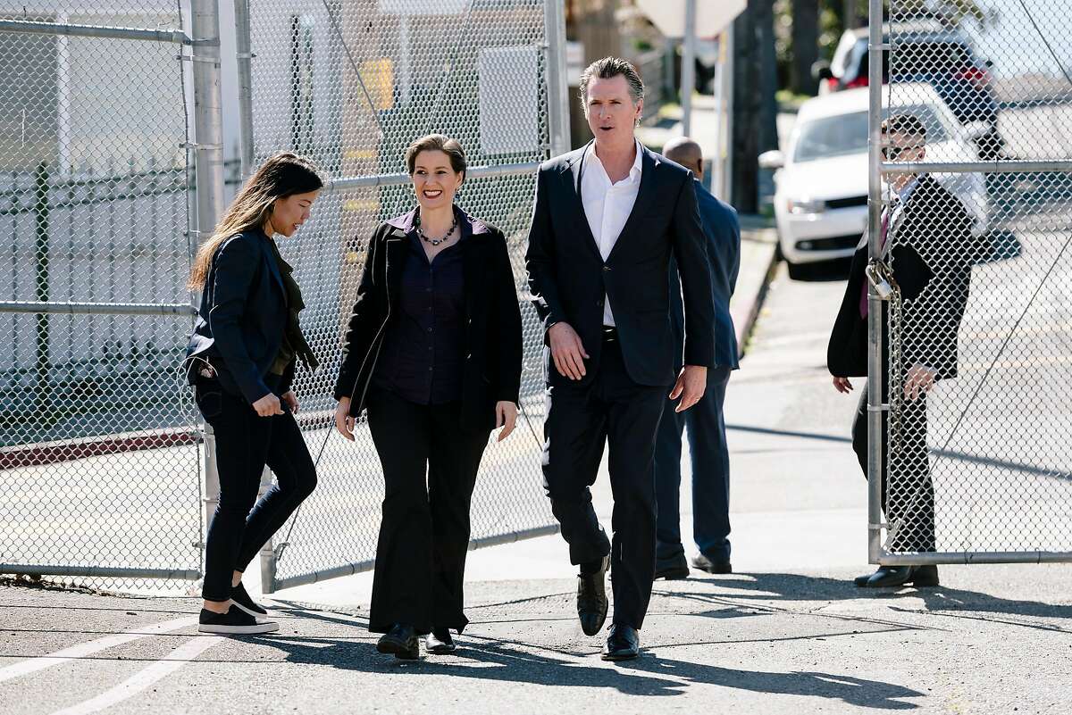 Governor Gavin Newsom is escorted by Oakland Mayor Libby Schaaf as he arrives for a campaign stop in support of state proposition 13 at Manzanita SEED Elementary School in Oakland, California, on Monday, March 2, 2020.