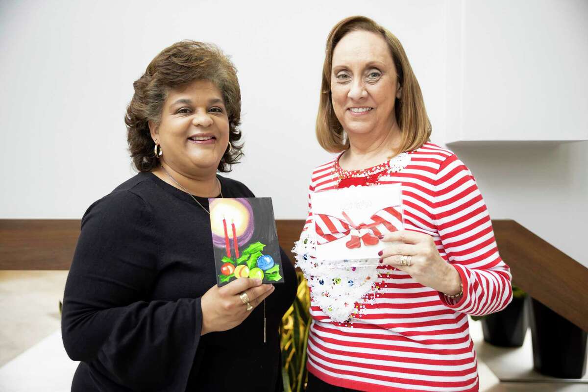Enid Goodman, left and Sheri Brown, right, both with Bridgewood Farms pose for a portrait with artwork made by their clients during a grant check distribution at the Community Foundation of Montgomery County, Thursday, Dec. 3, 2020. Bridgewood Farms received $6,800 from the Community Foundation to purchase equipment for their gym, to support nutrition and exercise programs for their clients.