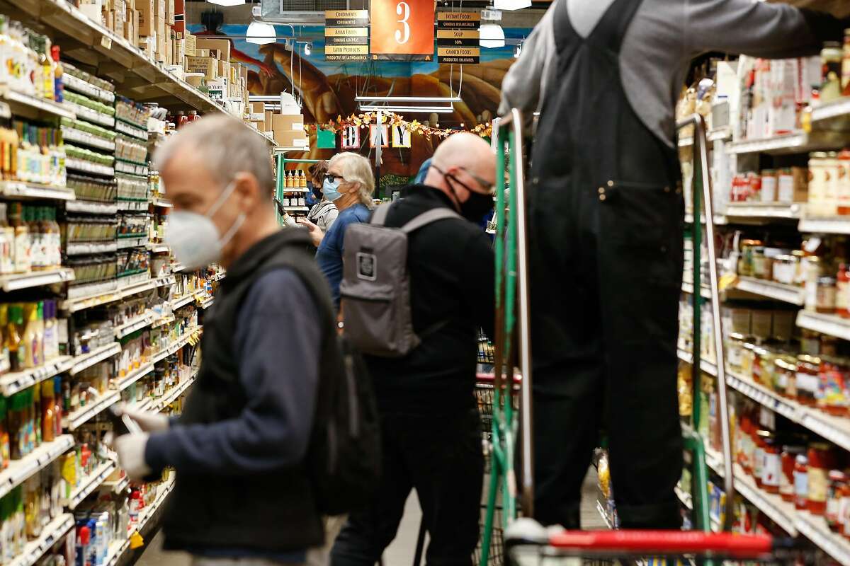 Shoppers look for items in Rainbow Grocery in November. Stores like Rainbow have added more suppliers since panic buying emptied some shelves early in the pandemic.