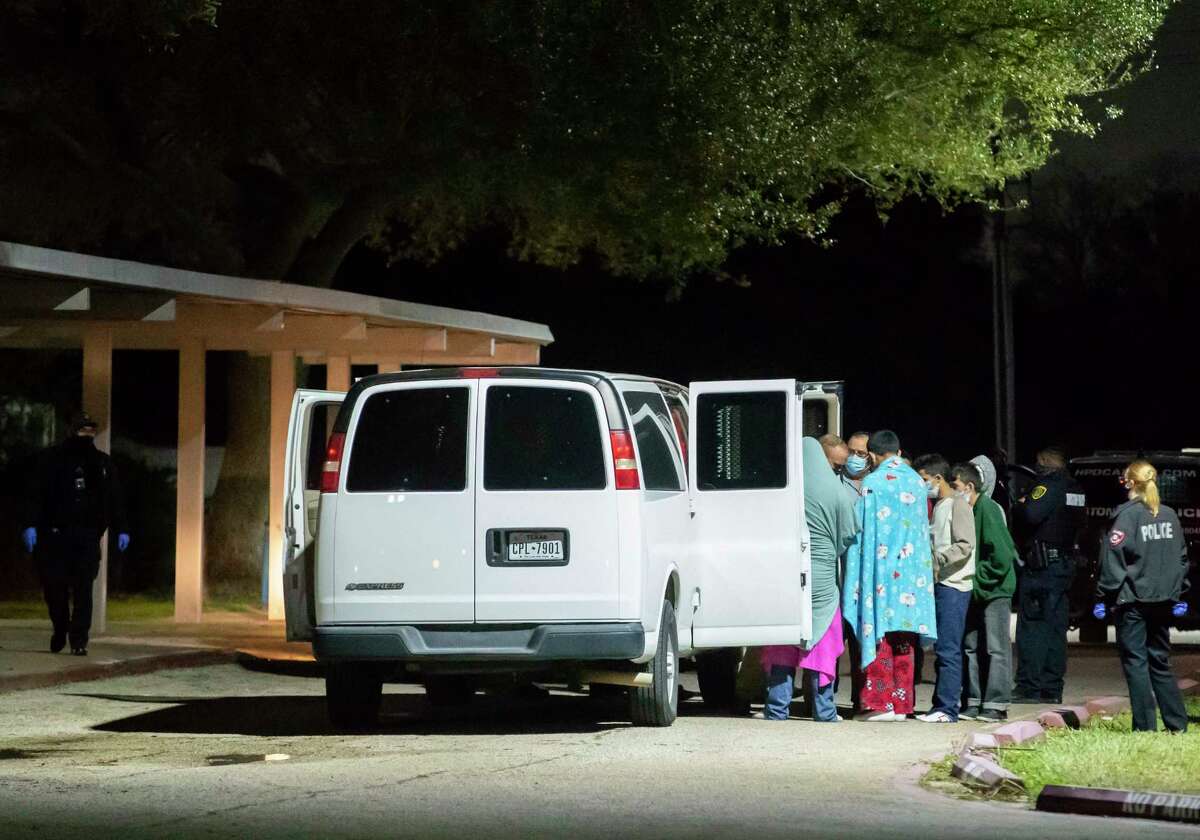 People are handcuffed together in pairs and loaded into vans as police investigate a possible human smuggling operation Thursday night after 25 men and one woman were found in a home in southwest Houston on Dec. 4, 2020. The people were taken to the gymnasium of nearby Ridgemont Elementary and were eventually transported away. Police responded to the home after an initial call by a person saying they had been kidnapped.