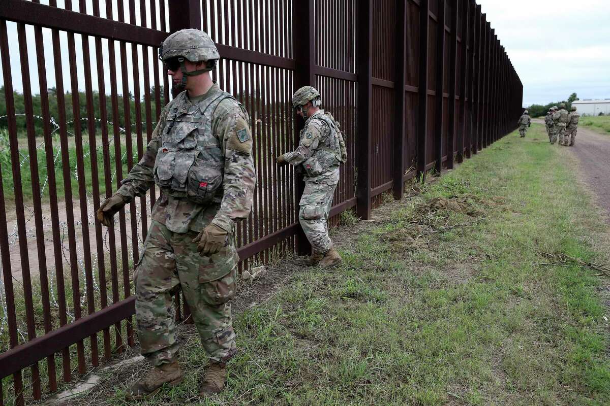 Soldiers secure razor wire to the U.S./Mexico border wall near downtown Brownsville, Texas, Monday, November 12, 2018. Around 5,800 troops were deployed for the border mission. U.S. President Donald Trump ordered the deployment in response to a migrant caravan from Central America.
