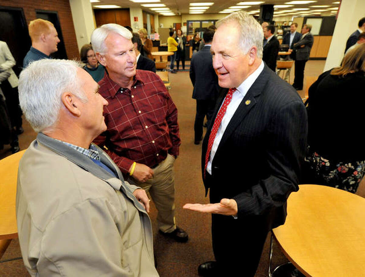 U.S. Congressman John Shimkus, right, talks with Steve Barker, left, and Randy Shroyer at the Lovejoy Library at SIUE before a presentation last year.