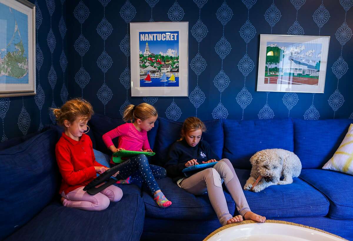 Annie Blanchard, 8 (left); her twin, Lizzie; and their sister Cate, 11, engage in Roblox games at their home in Mill Valley.