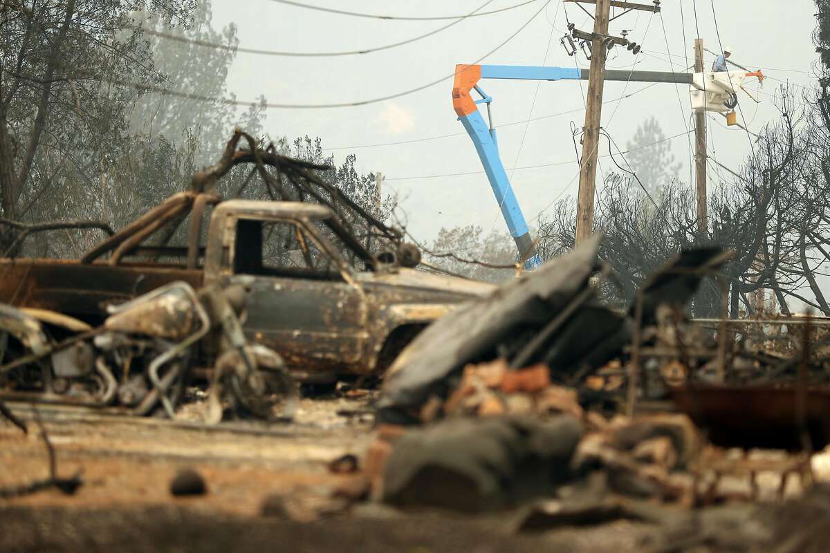 PG&E technicians work on restoring power after the Carr Fire in Shasta County in July 2018. The utility company has won approval for a rate increase after disastrous wildfires.