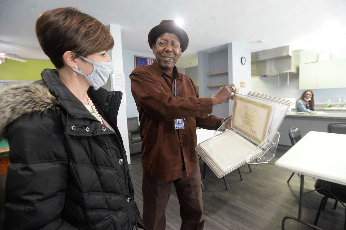 Spindletop Center's Heather Champion talks with Director Garry Lewis as he shows her his binder full of certifications and recognition as she stops to view The Hope Center, which reopened Monday after remaining closed and under repair since flooding during Tropical Depression Imelda. Photo taken Tuesday, December 1, 2020 Kim Brent/The Enterprise