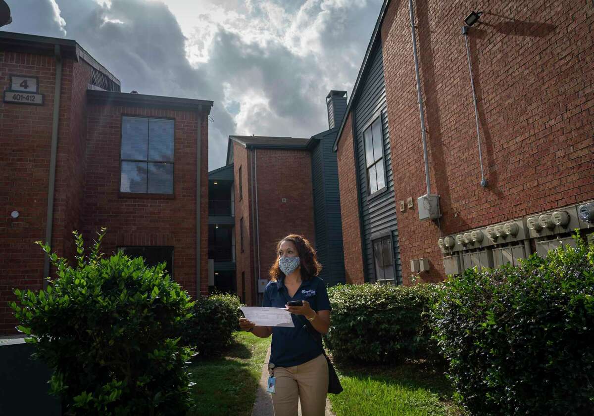 Chief Academic Officer Khechara Bradford looks for a student's apartment as she and other administrators go door to door visiting students as part of their "every day counts, attendance matters" campaign, Saturday, Nov. 14, 2020. About 28 percent of Spring students failed at least one class in the first marking period, roughly three times higher than normal. In middle and high school, the number reached 35 percent. District officials said attendance rates remain pretty steady, but kids aren't completing their coursework and aren't scoring as well amid the pandemic.