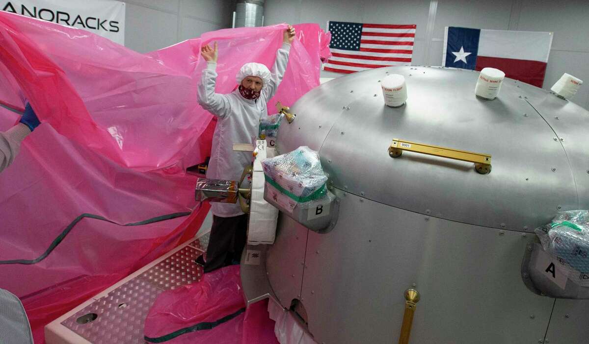 Nanoracks Senior Mechanical Designer Mark Rowley, from left, Director of Engineering Steven Stenzel and Michael Kerley, Craig Technologies' avionics technician lead in Florida, wrapping up the Bishop Airlock with a plastic cover before shipping it to Florida, Tuesday, Sept. 22, 2020, in Webster.