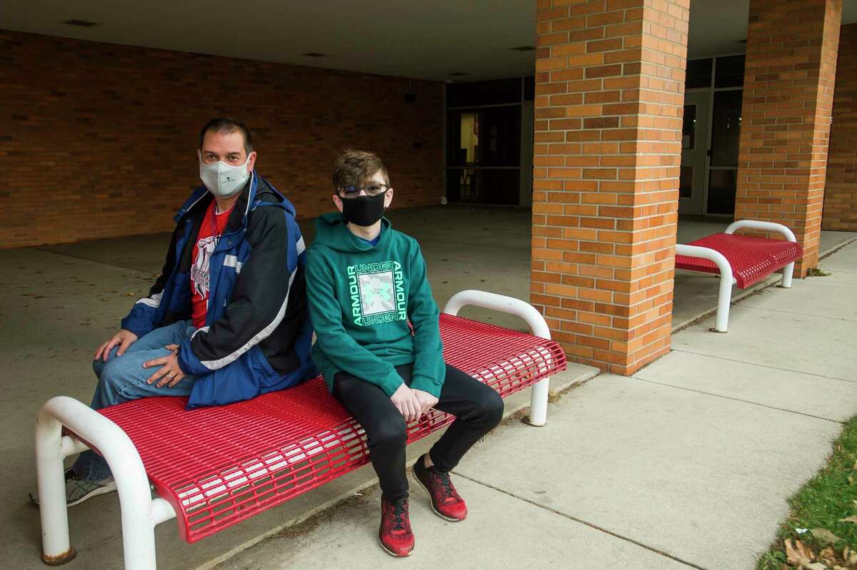 Brent Doty, a teacher at Jefferson Middle School, left, and Landon Stanford, a sixth-grade student, pose for a portrait Friday morning in front of the school. Doty performed lifesaving CPR on Stanford on Sept. 17 on the school playground. (Katy Kildee/kkildee@mdn.net)