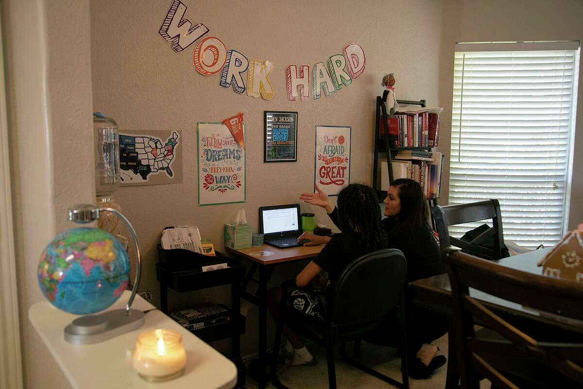 Hannah Sturgis talks with her son, Eden Jackson, 11, a sixth grader at Robert L. Vale Middle School, as he attends classes virtually at their home in San Antonio on Thursday.