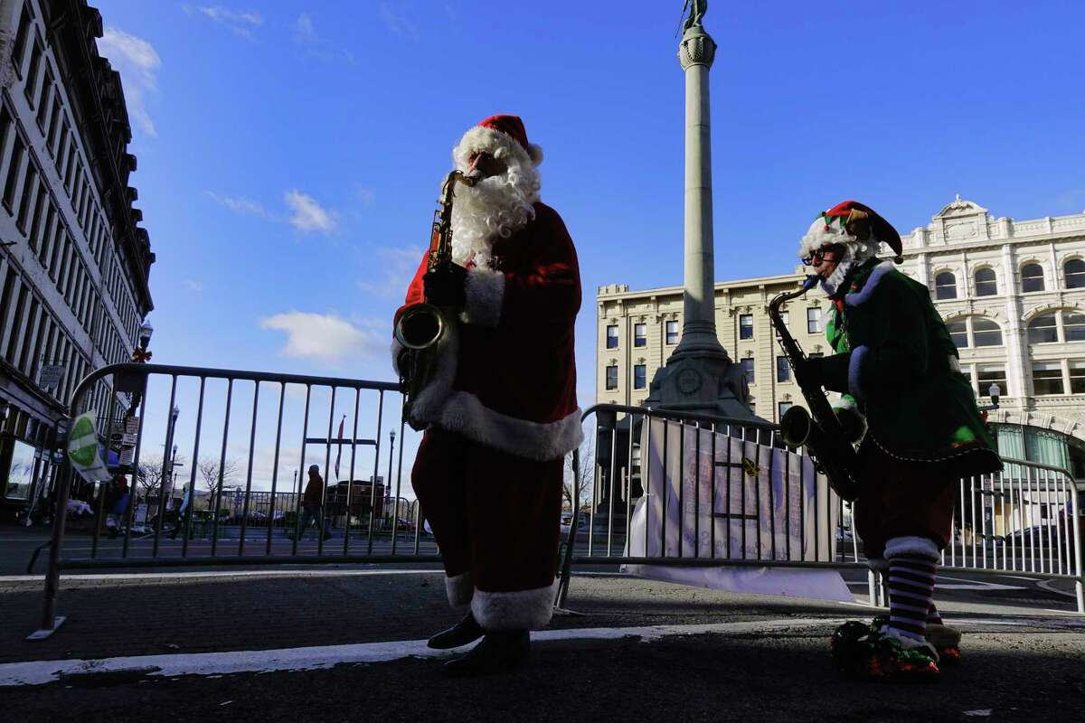 Luke McNamee, left, plays the part of Sax O Claus, and Josh Greenberg, plays the part of the elf, as the two performed on the street during the first day of the Troy Victorian Stroll events on Sunday, Dec. 6, 2020, in Troy, N.Y. 