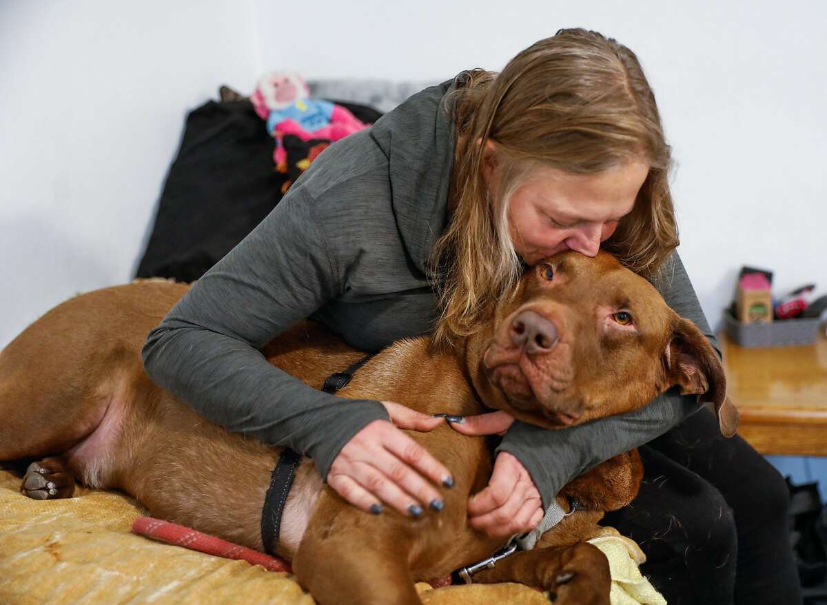 Jenn Oakley, who was previously homeless, cuddles her dog Fattie in her new studio apartment on Tuesday, Dec. 1, 2020 in Berkeley, California.This is the first time she�s had a place of her own in twelve years.