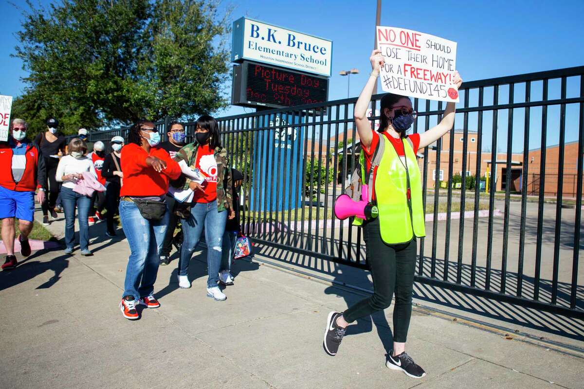 Chloe Cook, right, leads protestors by Bruce Elementary school during a protest walk in Fifth Ward on Dec. 6, 2020. Groups oppose the planned rebuild of Interstate 45 and the downtown freeway system.