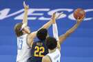UCLA guard Jake Kyman, left, and guard Jules Bernard, right, defend against a shot by California forward Andre Kelly (22) during the second half of an NCAA college basketball game Sunday, Dec. 6, 2020, in Los Angeles. (AP Photo/Kyusung Gong)