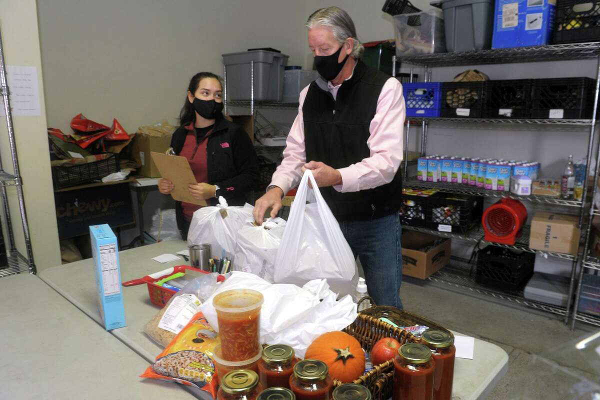 Site manager Greg Dobbs works with volunteer Susana Alvarado to fill orders at the Person-to-Person food pantry in Norwalk on Nov. 17.