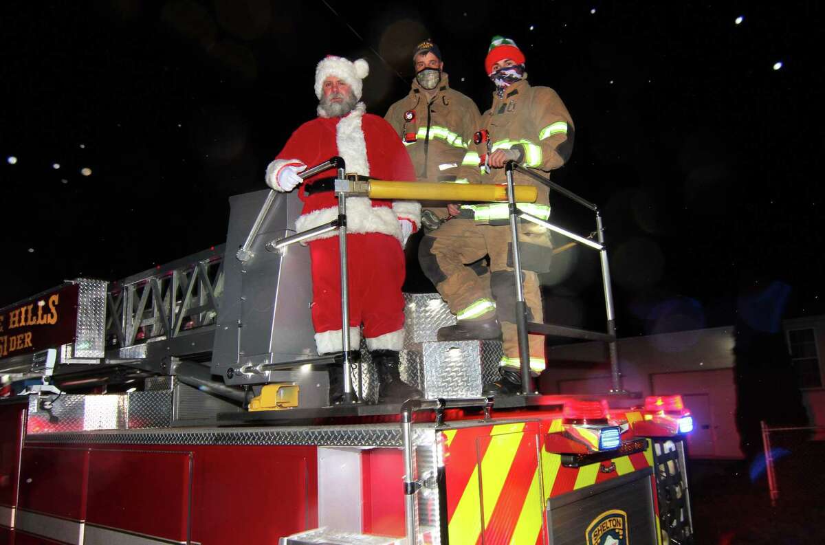 Santa arrives with firefighters Jim Norkus and Jon Bednarz, right, during the White Hills Fire House annual tree lighting in Shelton, on Saturday. Below, the tree is lit.