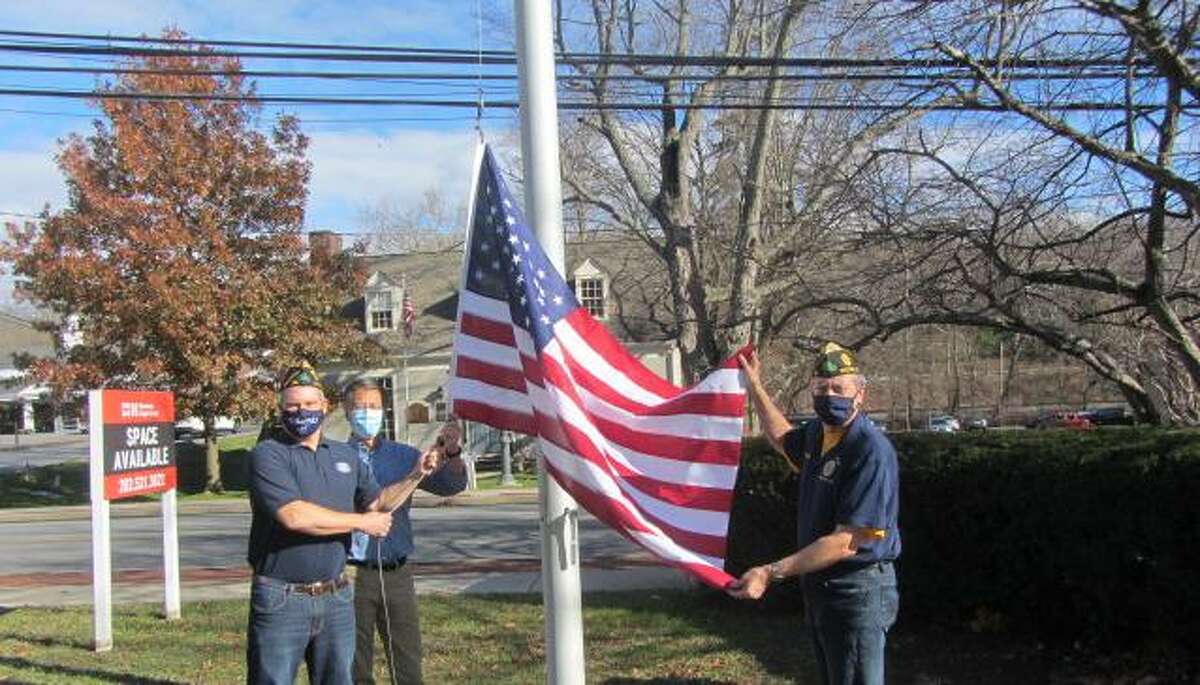 Raising the new flag in front of the gazebo on Nov. 27 in Wilton Center on are, from left, Jeff Turner, past Kiwanis Club president Kiwanis and American Legion member, Greg Chann, Kiwanis president and Legion member, and Bill Glass, Commander American Legion Post 86. The flag honors George McKendry, a founding member and early president of the Kiwanis Club.