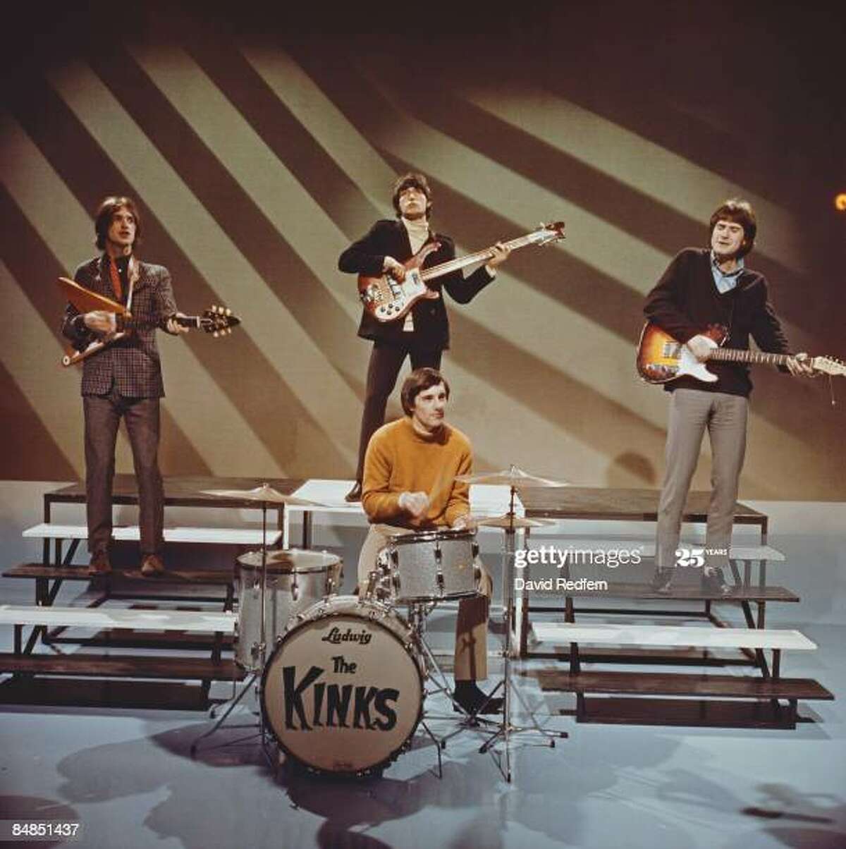 English rock group The Kinks, from left, Dave Davies (playing a Gibson Flying V guitar), Pete Quaife (behind, playing Rickenbacker bass guitar), Mick Avory and Ray Davies, perform on a television show at BBC Television Centre in London in December 1965. (Photo by David Redfern/Redferns)