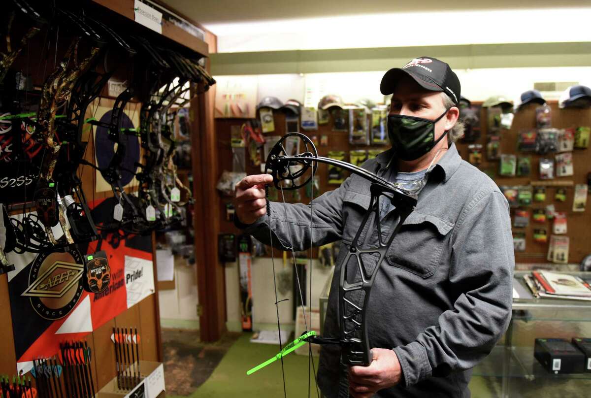 Mick McGuinness, owner of Brown's Archery Shop, shows the mechanics of a modern compound bow on Tuesday, Dec. 8, 2020, at his store in Schenectady, N.Y. McGuiness has seen a jump in business reflecting the increased demand for state hunting licenses. (Will Waldron/Times Union)