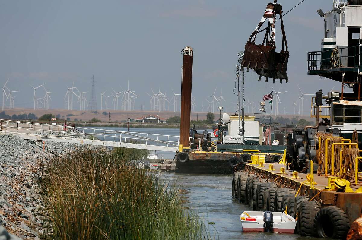 A massive crane works to build an emergency barrier in the West False River to deter tidal saltwater from entering the delta in 2015 in Oakley.