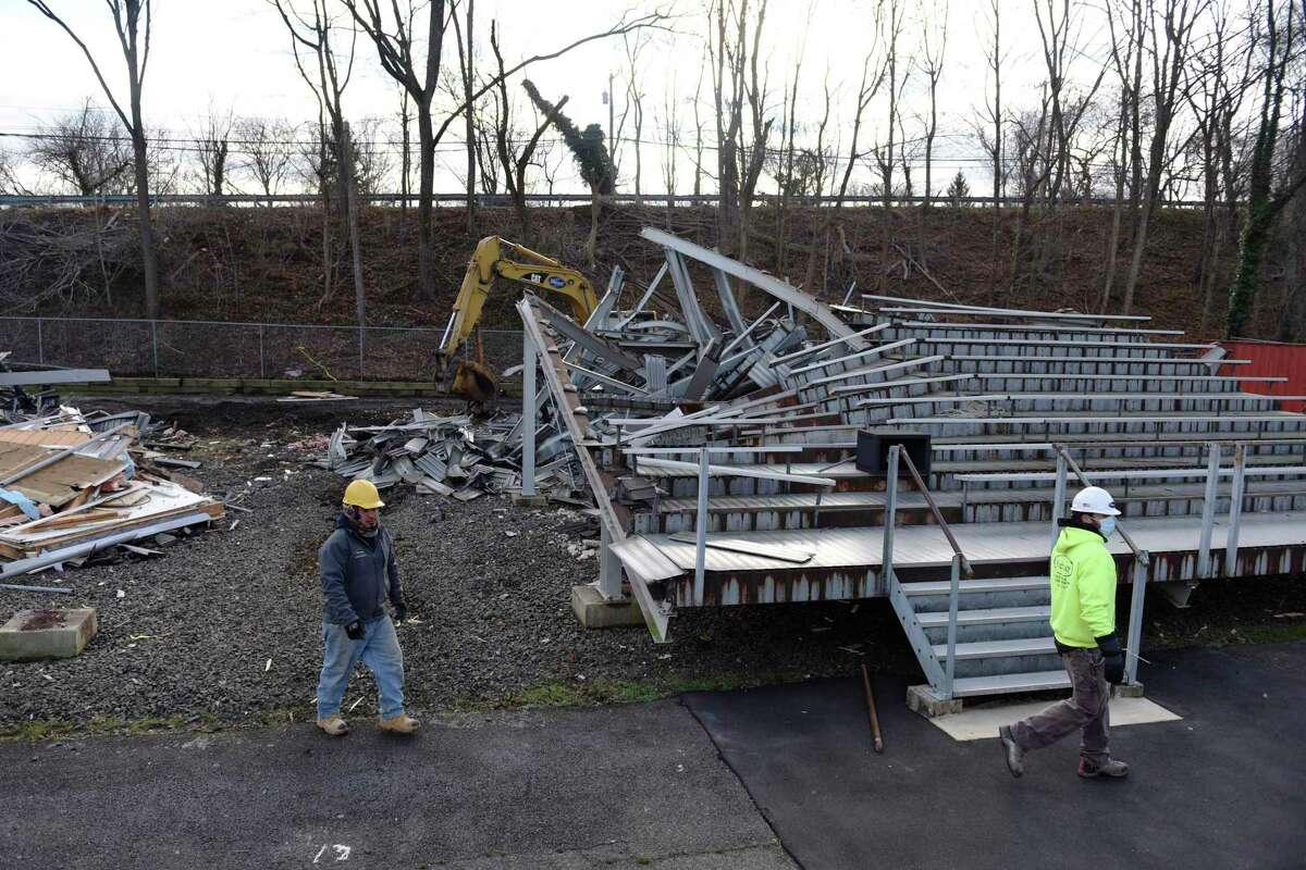 The Cardinal Stadium bleachers are torn down at Greenwich High School in Greenwich, Conn. Tuesday, Dec. 8, 2020. The demolition of the old bleachers marks the start of “Phase 1A” of construction, which includes the demolition as well as the construction of the new bleachers on the home field side, a new press box that will have an elevator and new bathrooms, a new team room that will go underneath the new bleachers, and other improvements.
