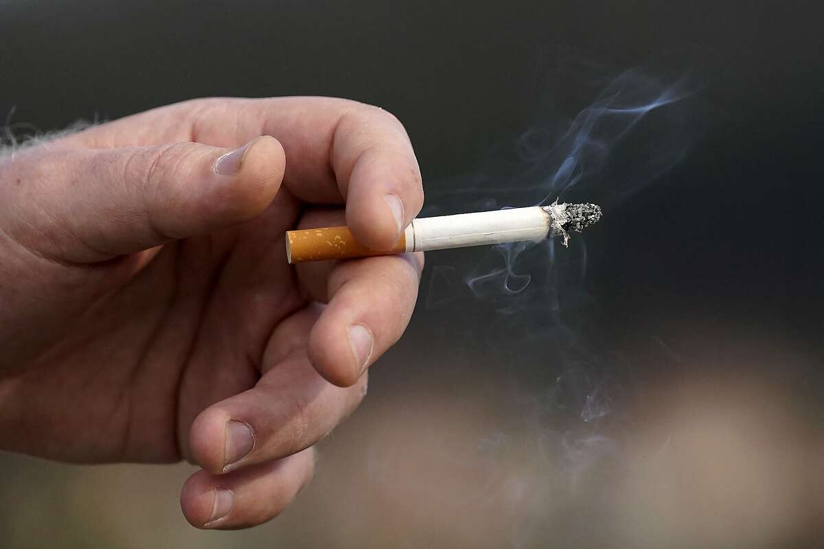 A man who did not want to be identified holds a lit cigarette while smoking in San Francisco, Wednesday, Dec. 2, 2020. San Francisco’s Board of Supervisors reversed course on banning smoking in multi-unit buildings on a perfunctory second vote - a rare move - after protests from residents who said they could be hurt under the law.