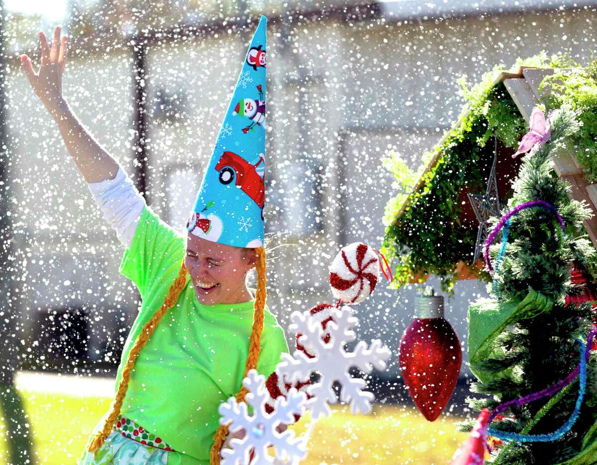 Chrissa Silva with Carolina Creek Christian Camp enjoys fake snow during the annual Christmas parade through downtown Conroe, Saturday, Dec. 14, 2019. The parade is Saturday at 1 p.m. in downtown Conroe.