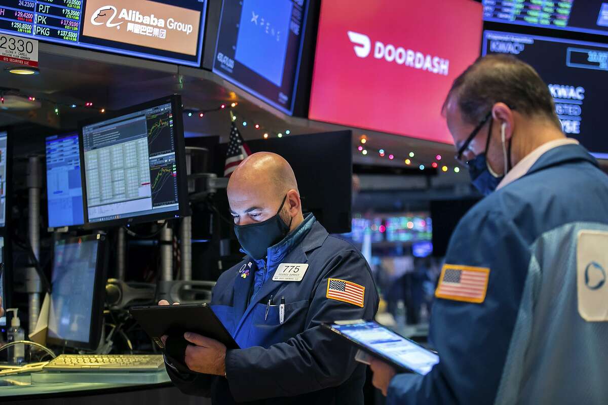 Traders on the New York Stock Exchange watch DoorDash’s worth climb to $72 billion on its first day of trading as a public company Wednesday.