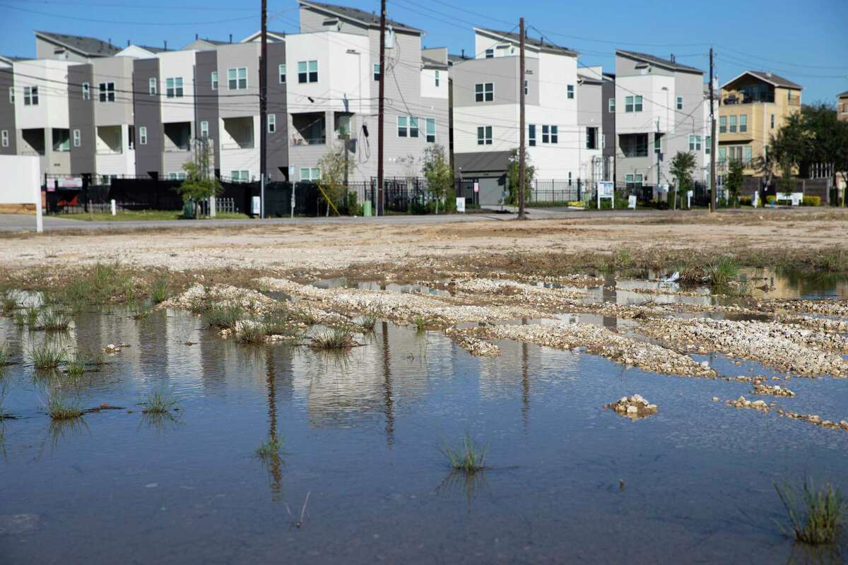 A puddle sitting on an empty field at Clinton and Jensen Drives that is waiting to be developed Wednesday, Dec. 9, 2020, at Fifth Ward in Houston. A city agency supports a huge development proposed along south of Clinton Drive between Jensen Drive and Hirsch Road. Community activists worry the development will drive out existing low-income residents in the historical Black neighborhood.
