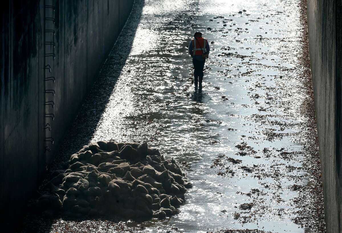 A cleanup crew removes hazardous material from the flood control channel adjacent to the Iron Horse Trail just south of Ygnacio Valley Boulevard in Walnut Creek.