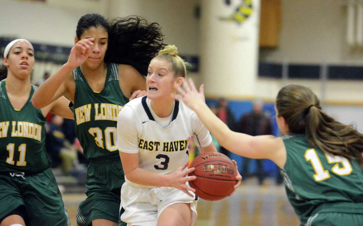 East Haven’s Makenzie Helms splits the defense of New London’s Taina Pagan (30) and Angelina Munoz (15) in 2018.