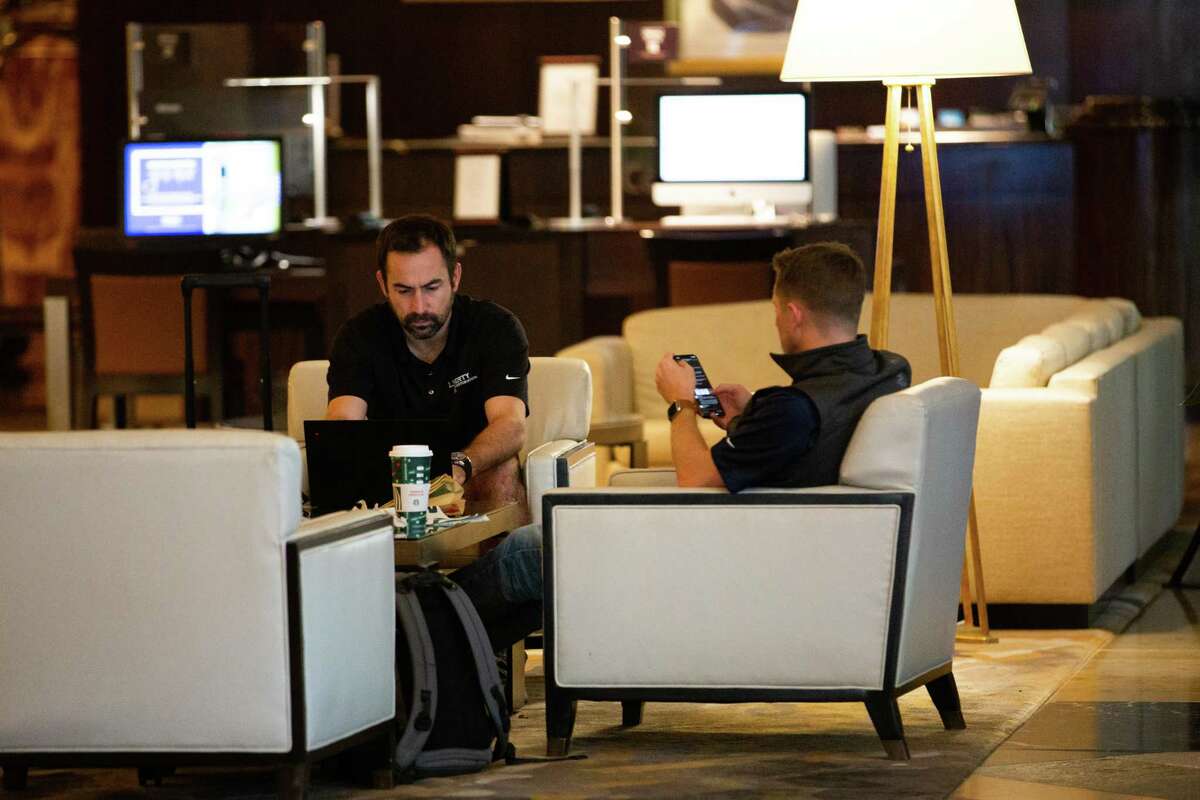 Hilton Americas-Houston guests have coffee on the hotel lobby, Wednesday, Nov. 11, 2020, in Houston.