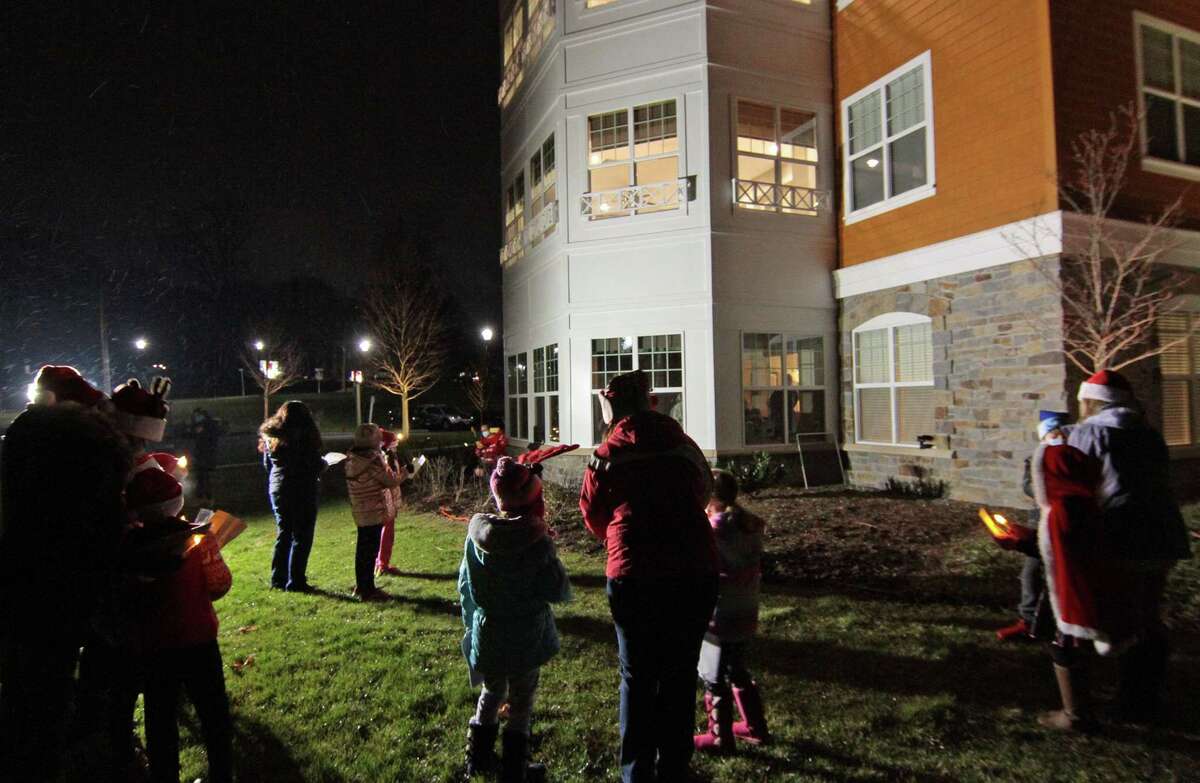 Children from Newtown Youth and Family Services sing Christmas outside for senior residents at Maplewood at Stony Hill, in Bethel, Conn., on Wednesday Dec. 8, 2020.