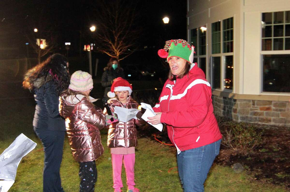 Candace Bohr, with Newtown Youth and Family Services, lead children in singing Christmas carols for senior residents at Maplewood at Stony Hill, in Bethel, Conn., on Wednesday Dec. 8, 2020.