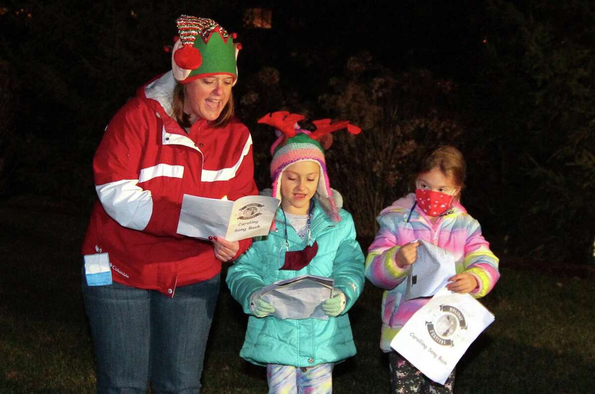 Candace Bohr, with Newtown Youth and Family Services, and her children Carrie and Emily, right, sing Christmas carols for senior residents at Maplewood at Stony Hill, in Bethel, Conn., on Wednesday Dec. 8, 2020.