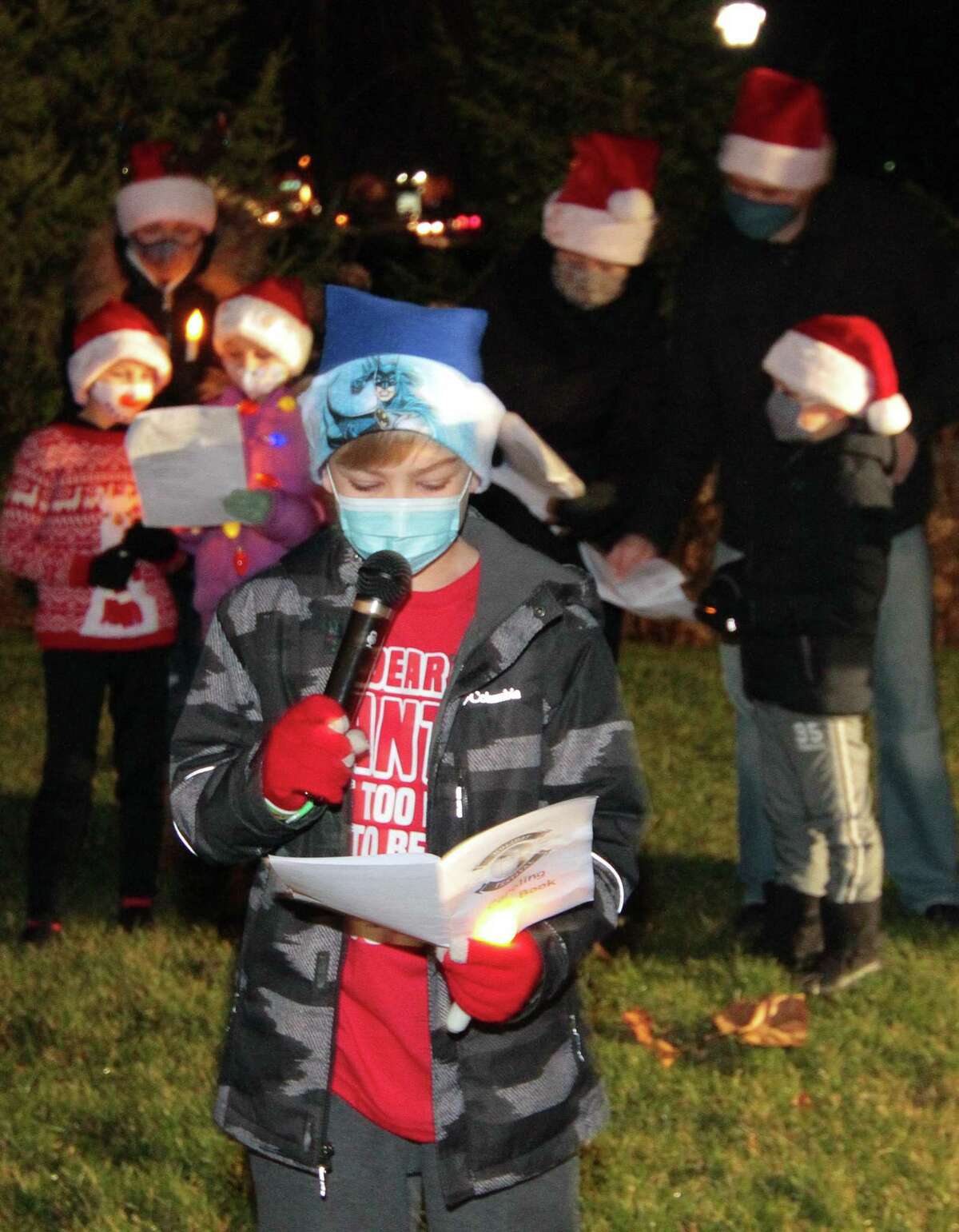 Chase Moran, 9, joins with other carolers to perform outside for senior residents at Maplewood at Stony Hill, in Bethel, Conn., on Wednesday Dec. 8, 2020. Newtown Youth and Family Services organized the event.