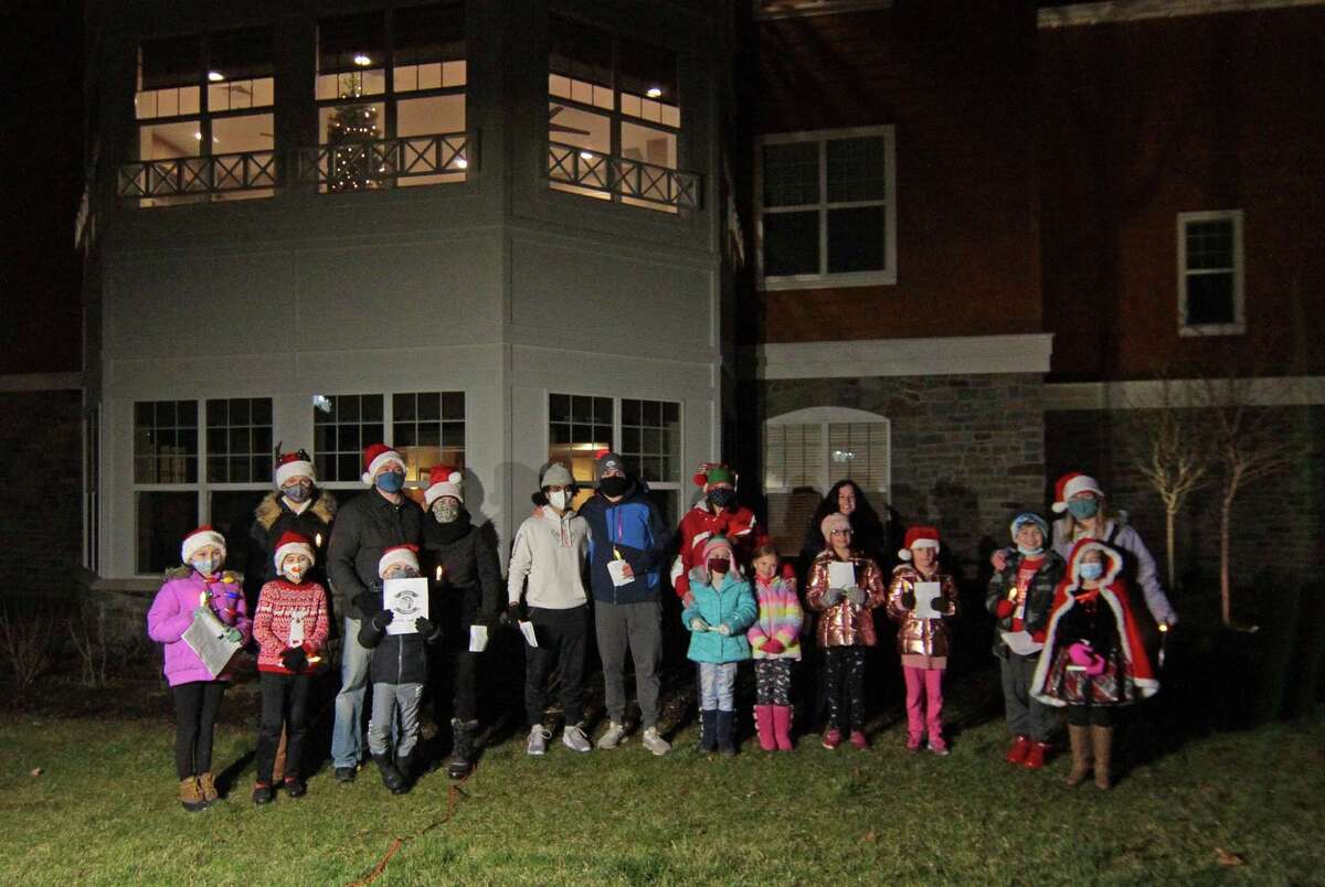 Carolers from Newtown Youth and Family Services perform outside for senior residents at Maplewood at Stony Hill, in Bethel, Conn., on Wednesday Dec. 8, 2020.