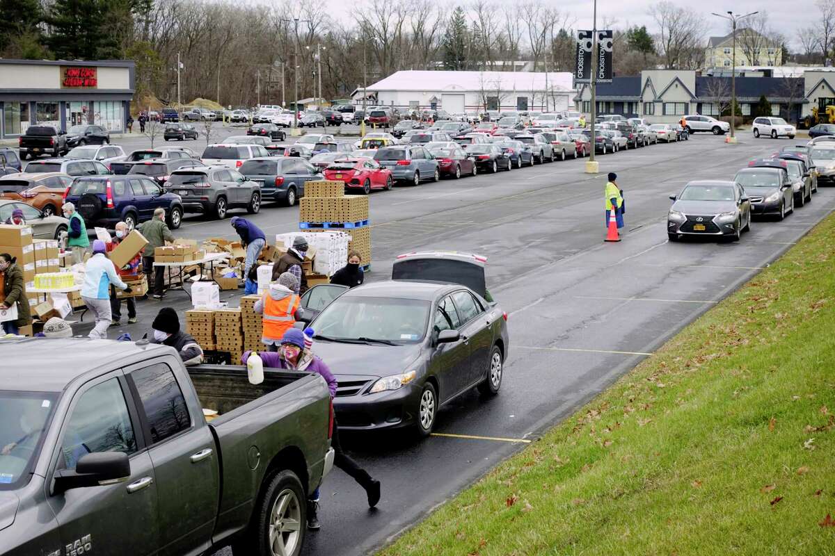 Drivers in their cars are lined up as they wait their turn as volunteers load food into vehicles during a mass food distribution put on by Catholic Charities of the Diocese of Albany, and the Regional Food Bank of Northeastern New York on Thursday, Dec. 10, 2020, in Schenectady, N.Y. The next mass food distributions will be on Monday Dec. 14th, at Metropolitan Church, located at 105 2nd St, in Albany, and then on Wednesday, Dec. 16th, at SUNY Schenectady college. Both events begin at 9:30AM. The distribution is open to the public and no pre-registration is required. Food is distributed on a first-come, first-served basis, and the distribution will last until supplies are gone. (Paul Buckowski/Times Union)