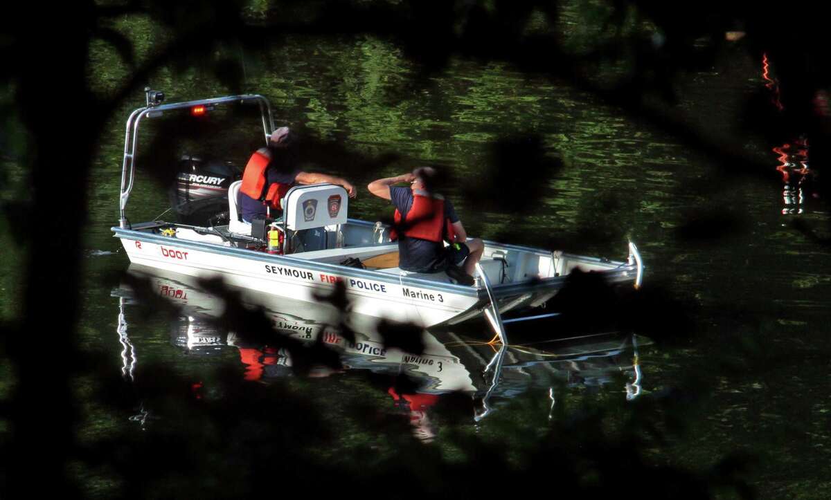 Officials investigate after a vehicle landed in the Housatonic River in Seymour, Conn., on Friday July 31, 2020. First responders rushed to the area of 179 Roosevelt Drive (Route 34) shortly before 4 p.m. after a crash on the side of the road catapulted a vehicle into the Housatonic River, according to initial dispatch reports.