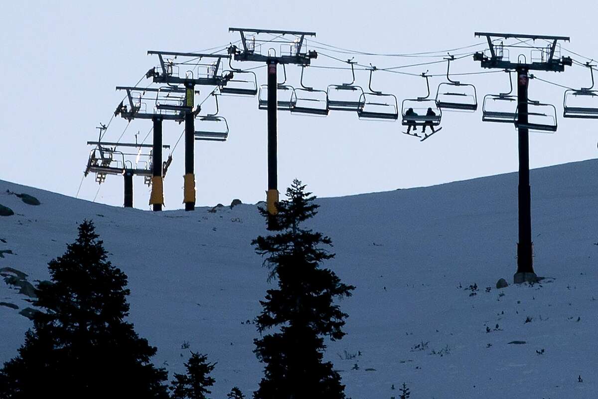 Snowboarders ride the ski lift to the top of Heavenly Mountain in South Lake Tahoe, Calif. Thursday, December 10, 2020. Vacation travel to Lake Tahoe will be banned for at least three weeks starting Friday due to a regional rise in the number of COVID-19 hospitalizations.